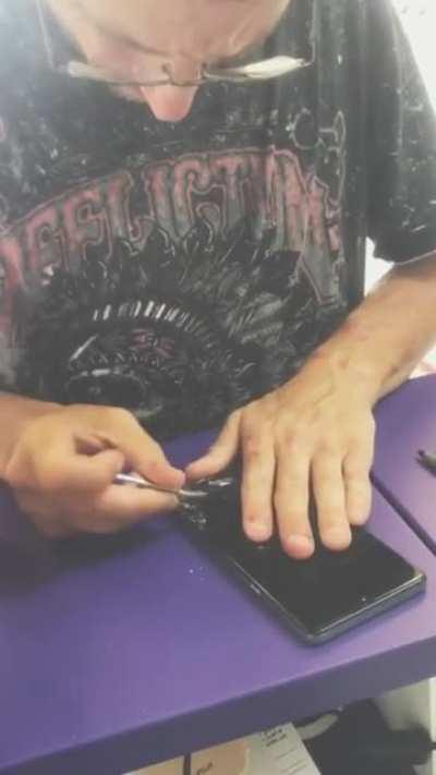 Tweaker dismantles his phone while accusing repair shop