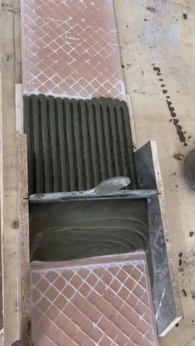 Spreading cement on tiles.