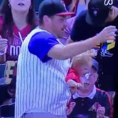 Father drops his child momentarily to catch the ball... And the beer