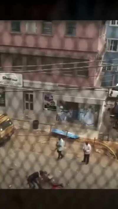 Nigerian policemen shooting at a downed protester
