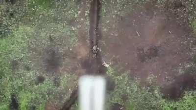 A Ukrainian drone dropping multiple grenades on a Russian soldier