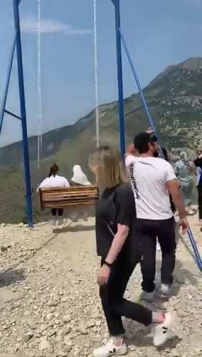 Swinging on a sketchy cheap playground swing set on the edge of a cliff, what could possibly go wrong?