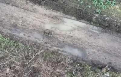 Three orcs lying in the mud next to a street. A drone kills two of them with precise drops