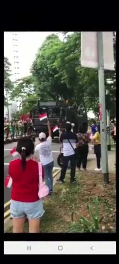 Old man nearly gets run over by a military armoured vehicle column during Singapore's 55th celebration of its independence.