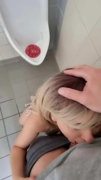 On her knees at the urinals