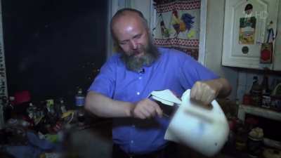 A man rummages through garbage dumpsters and brings home all the discarded food. He keeps it there for months.