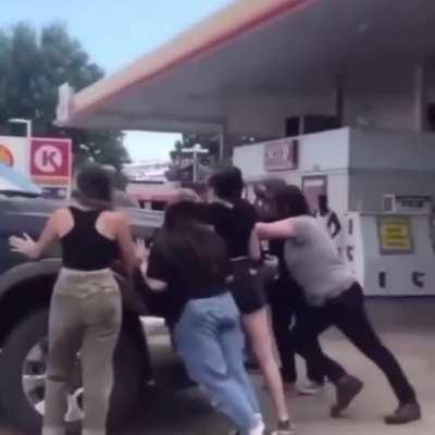 Protesters blocking someone from getting gas.