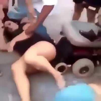 2 women fight on the ground and a cripple joins in