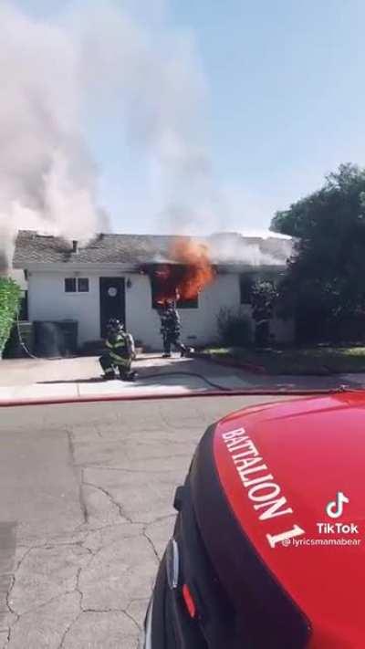 Firefighters battle a fire near a downed power line