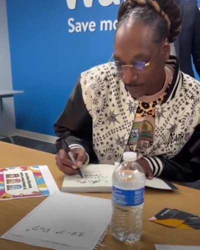 Snoop Dogg signing his autograph, in Japanese, at a Walmart