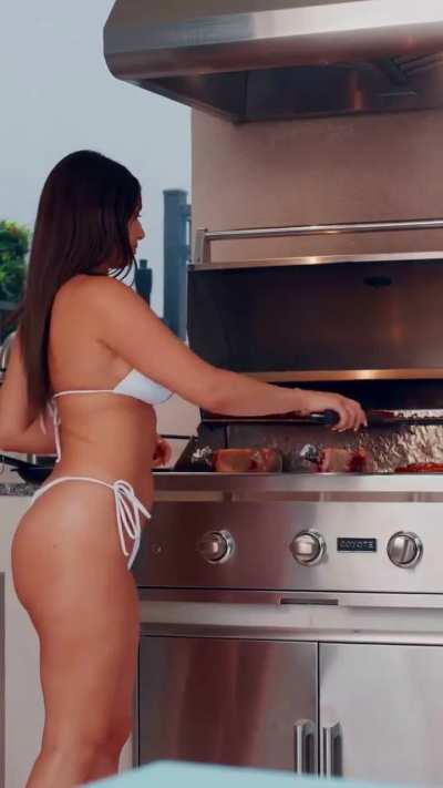 Amber Ajami in a bikini cooking