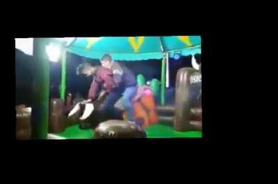 Two guys on a mechanical bull