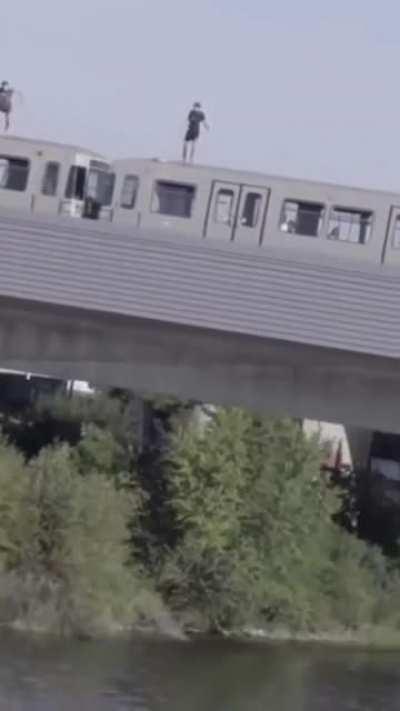 Hold Our Red Bulls as we leap off the moving train into the river.