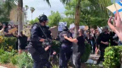 Los Angeles, CA: LAPD officers beat the sh*t out of several unarmed peaceful protestors for sport, while other cops in the pack shoot them at close range