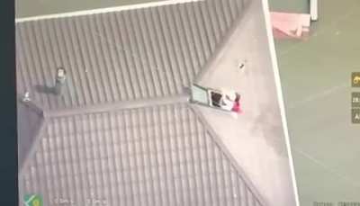 UAV operators deliver a bottle of water by drone to a woman and her child trapped on the roof of their house. Occupied left bank of the Kherson region, Oleshky.