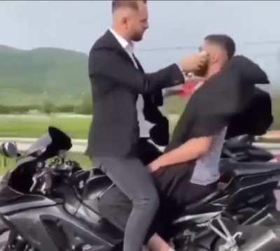 This guy is getting a haircut on a motorcycle