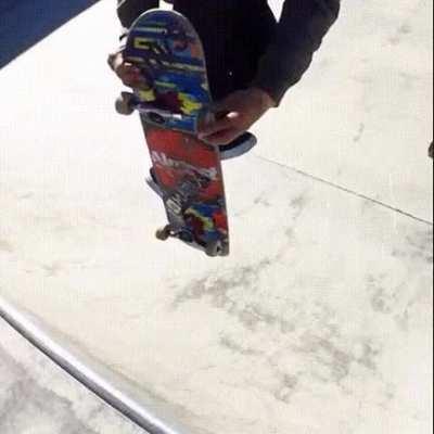 Skateboarder changing wheel mid-jump