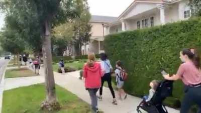 Anti-vaxxers harass parents and children outside of elementary school.