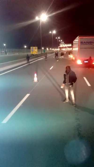Imigranti pasnici pe autostrada in Nordul Frantei ii intampina pe soferii de TIR cu panselute ca sa ii ajute sa treaca canalul manecii :x