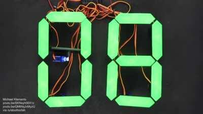 Mechanical 7-segment display clock driven by 28 servos controlled by an Arduino