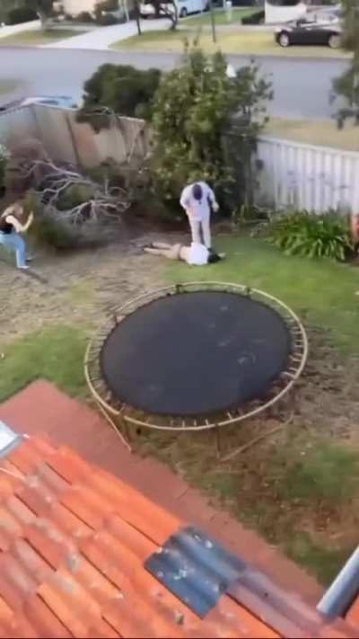 Guy jumps off roof onto tramp