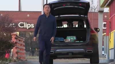 Restaurant worker chops meat on pavement outside of teriyaki restaurant in Kansas City.