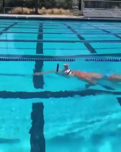 Olympic Gold Medalist, Katie Ledecky, swims with a glass of chocolate milk on her head