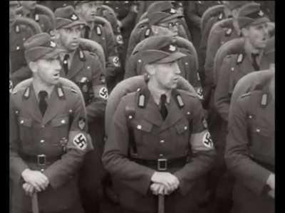 Footage from the propaganda film “Triumph of the Will”, 1935. The Reich Labor Service has an outdoor rally at Nuremberg, presenting in front of Hitler and other Nazi officials.