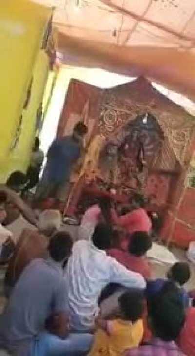 Religious nut beating a woman inside a temple