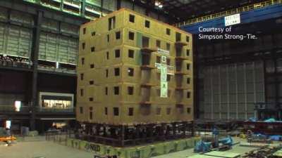 A building undergoes a seismic test on a shake table