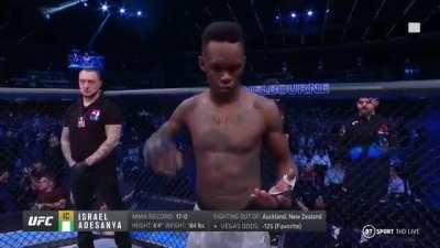 UFC fighter Israel Adesanya mimes writing his opponent's name in a deathnote.