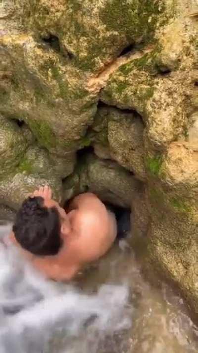 Man goes in narrow underwater cave.