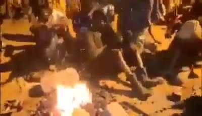 African man sits on fire