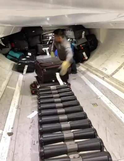 How the baggage handlers load bags on a plane.