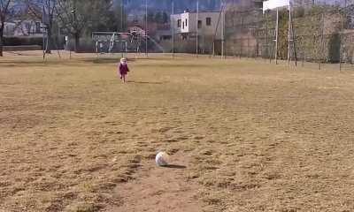 Guards watch as girl does a 50 meter run-up to kick a ball