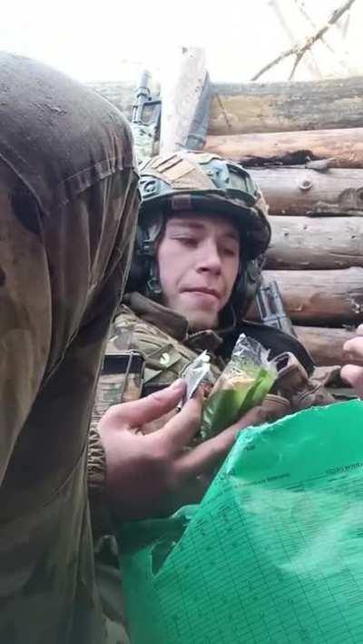 Ukrainian Soldier Eating a Snack in a Trench While the Shells are Landing Somewhere Nearby