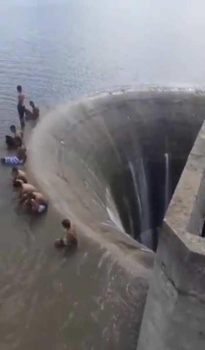 Watch as group of kids stand inches before a dam drain in Águas Vermelhas, Minas Gerais, Brazil 😳