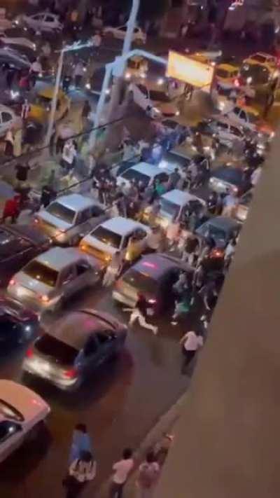 Basiji getting beaten by a crowd in Tehran while a woman cheers for them