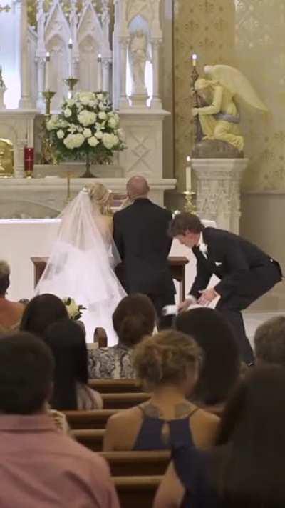 Best man fixes groom suit during wedding
