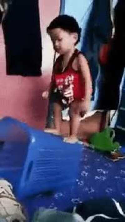 Kid tries to pin the hamper