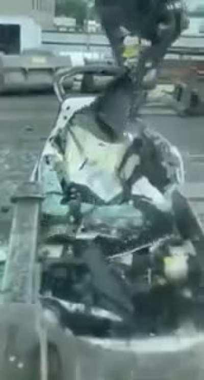 Destroying cars with giant metal claw.