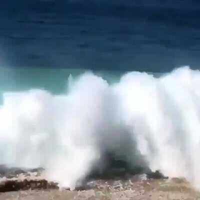 Wakeboarding straight into a breaking wave coming upon the land