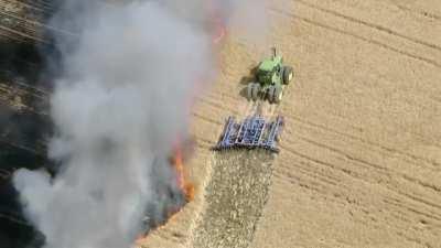 Farmer trying to save a field from fire