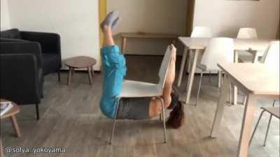 Professional rock climber performing on a chair without touching the ground