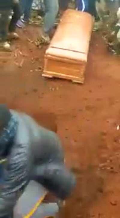 People fighting on someone's coffin