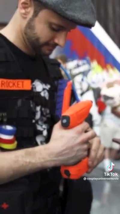 Guy helping cosplayers fix their outfit when they need it