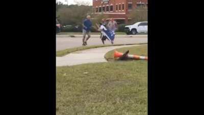 Man attempts to use political flag as a sword in the middle of an intersection