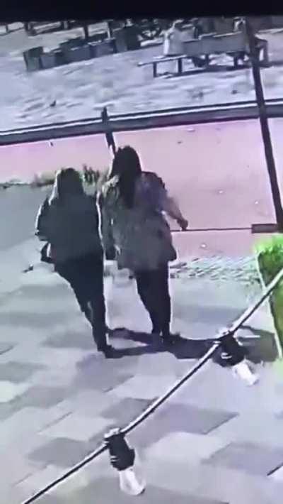 Two women trying to cross the road