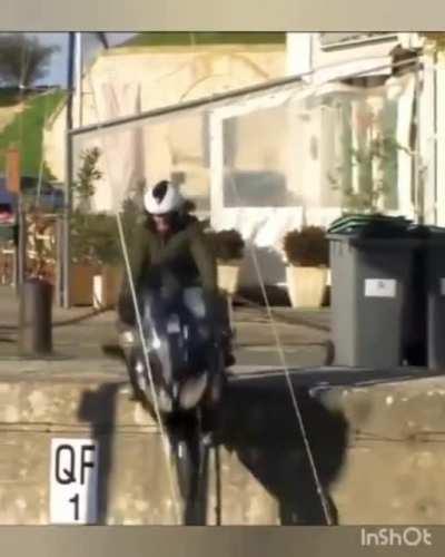 Guy tries to ride motorcycle on edge, falls off