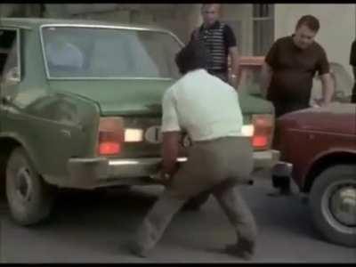 Franco Columbu lifting a car in Pumping Iron